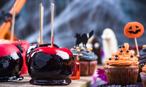 Glazed candy apples on Halloween party table.